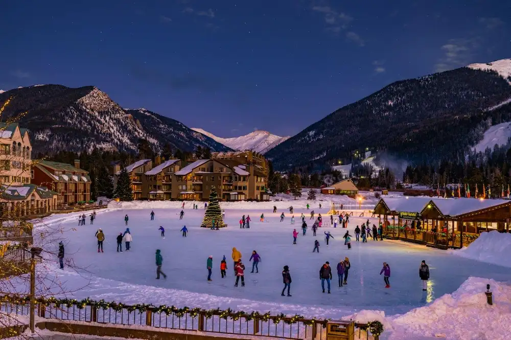 Families ice skating at Keystone Resort with mountain backdrop